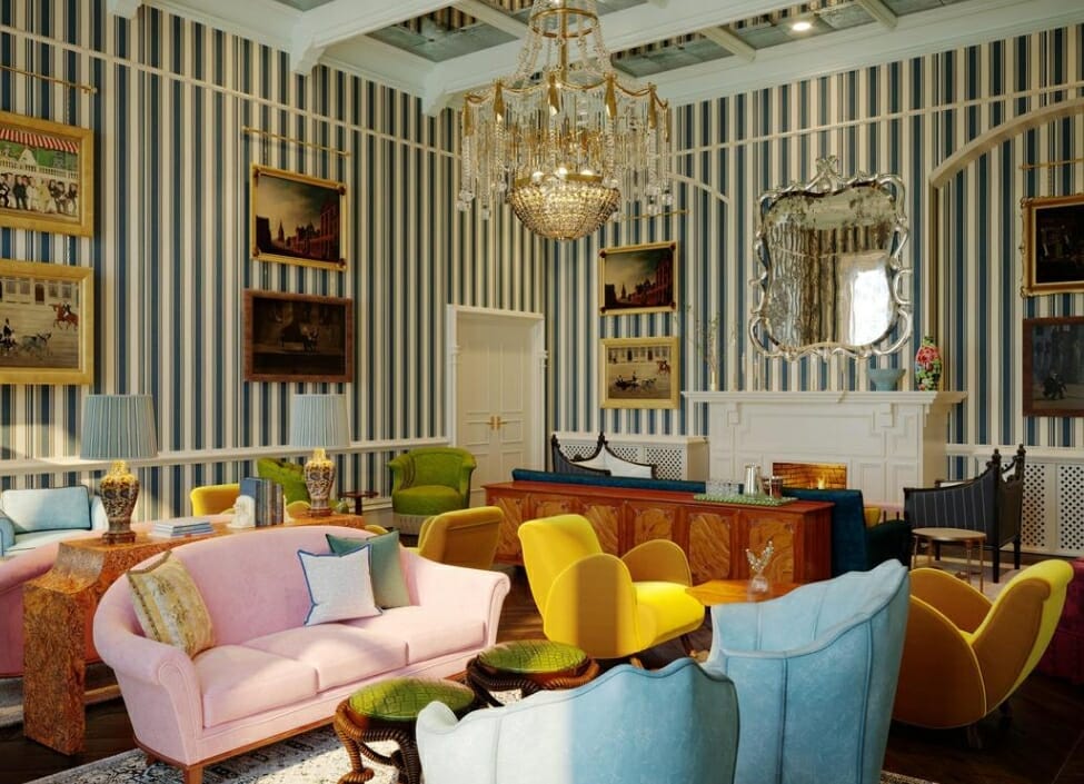 lobby of the Randolph Hotel in Oxford with different coloured sofas, a chandelier, striped wallpaper, and paintings on the wall
